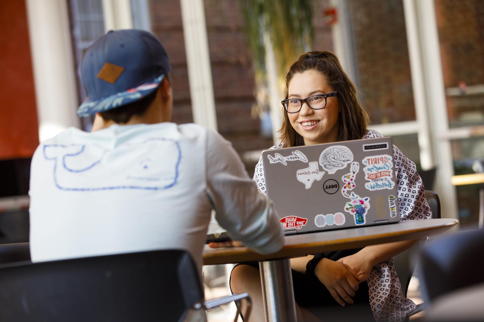 Students Talking at a table with computer in front of them