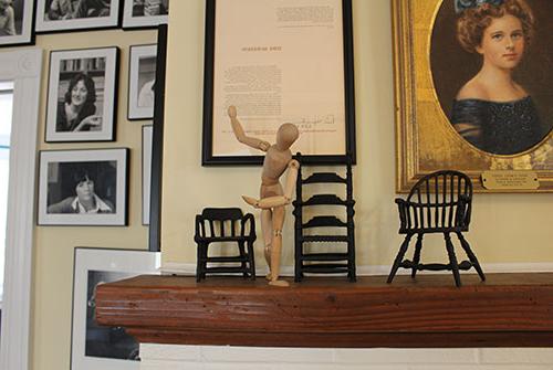 Wooden sculpture posed on wooden mantle in Literary House